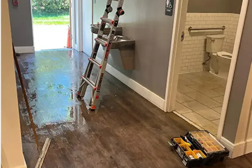 Wet hallway floor outside a restroom in a commercial building